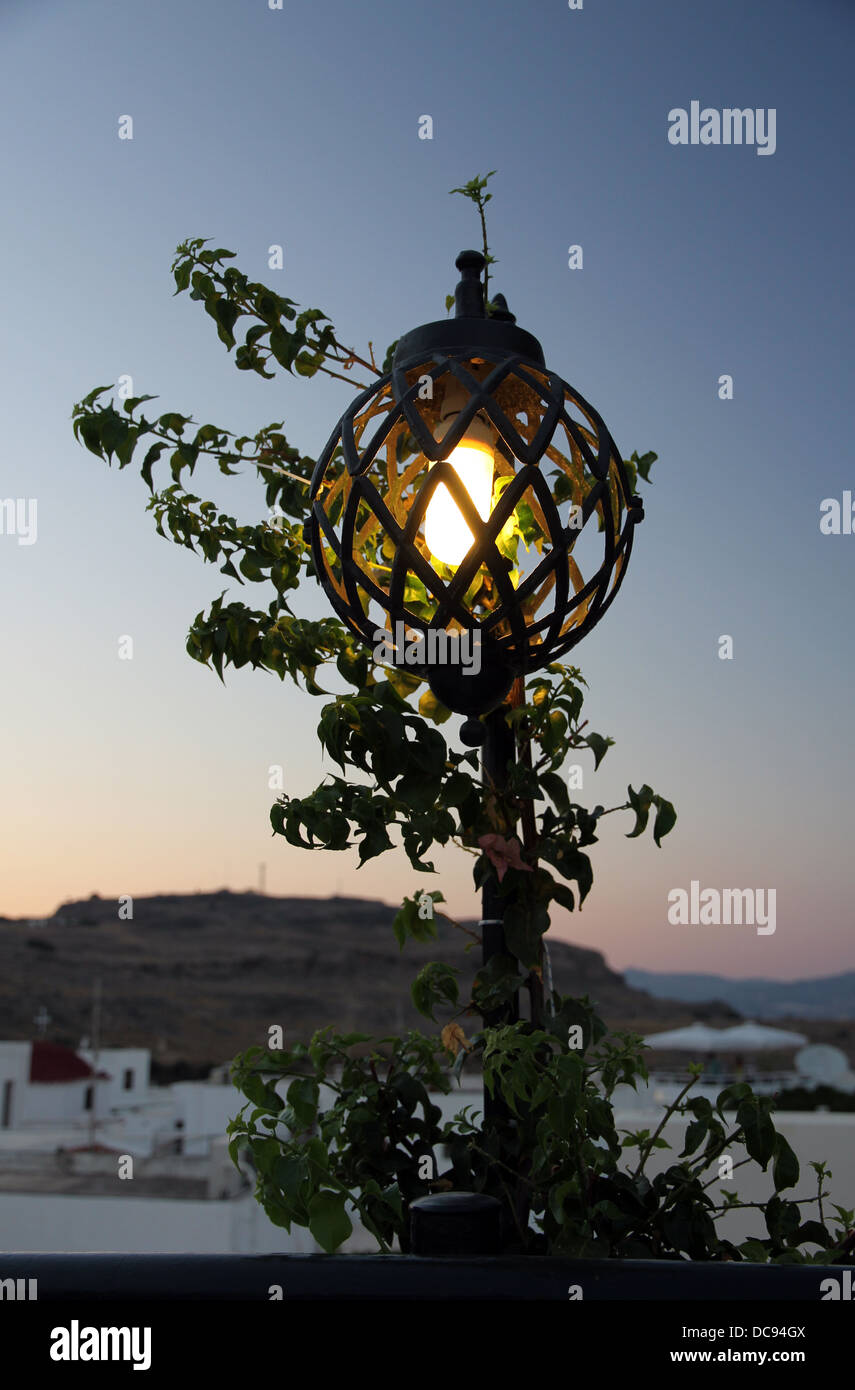 Vue sur Lindos, Rhodes, Grèce, du restaurant sur le toit au coucher du soleil, fermer sous le fort et de l'Acropole de Lindos. Banque D'Images