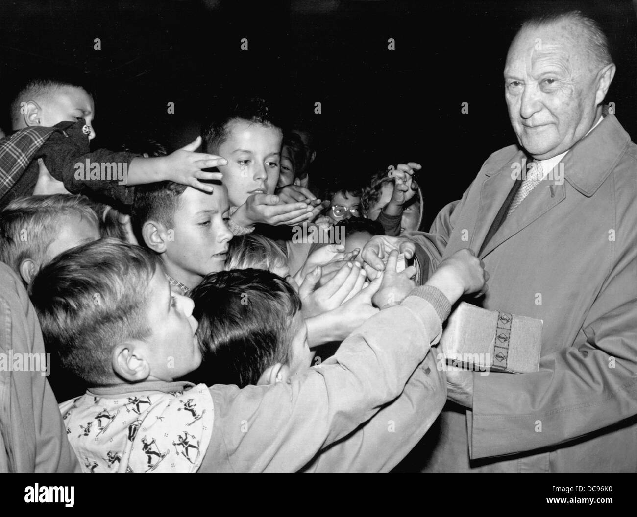 Le chancelier allemand Konrad Adenauer (CDU) donne des chocolats pour les enfants lors d'une campagne électorale à Schoenbach le 11 septembre en 1957. Banque D'Images