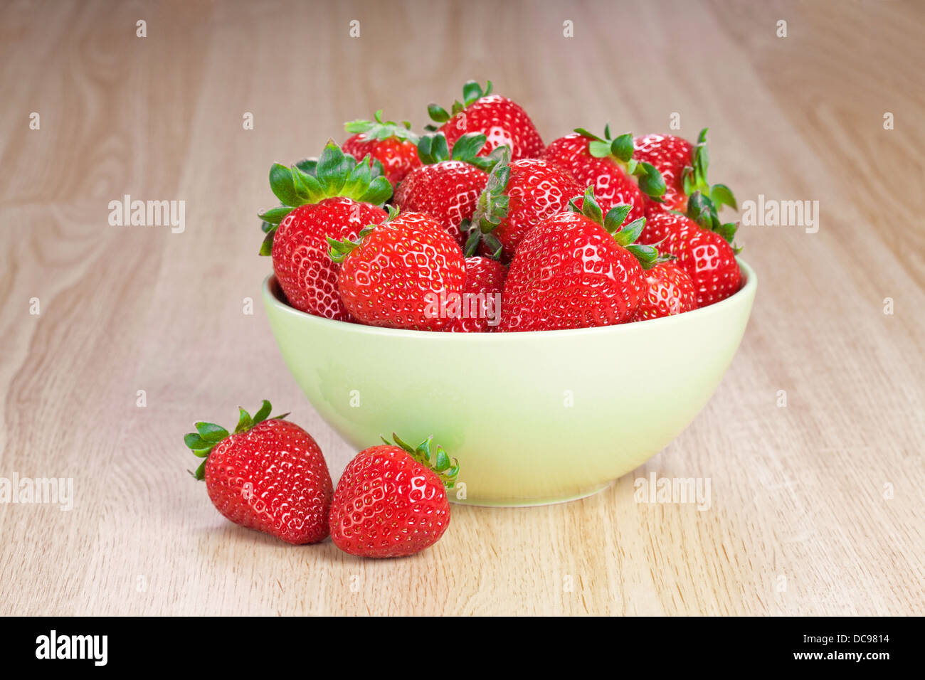 Fraises fraîches dans une assiette sur la table en bois Banque D'Images
