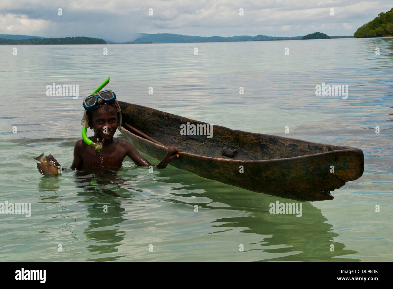 Garçon de pêche avec son canot et harpoon Banque D'Images