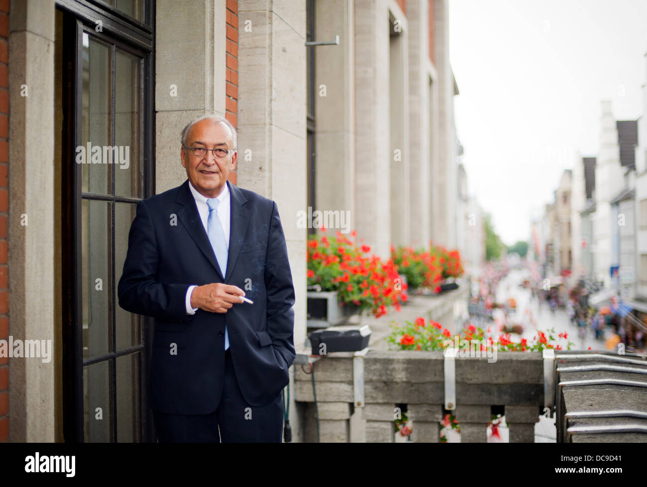 Maire de Neuss Herbert Napp se tient sur le balcon à l'extérieur de son bureau à l'hôtel de ville de Neuss, Allemagne, 13 août 2013. Napp envisage de contester une ordonnance officielle qui lui interdit de fumer dans son bureau. Photo : JAN-PHILIPP STROBEL Banque D'Images