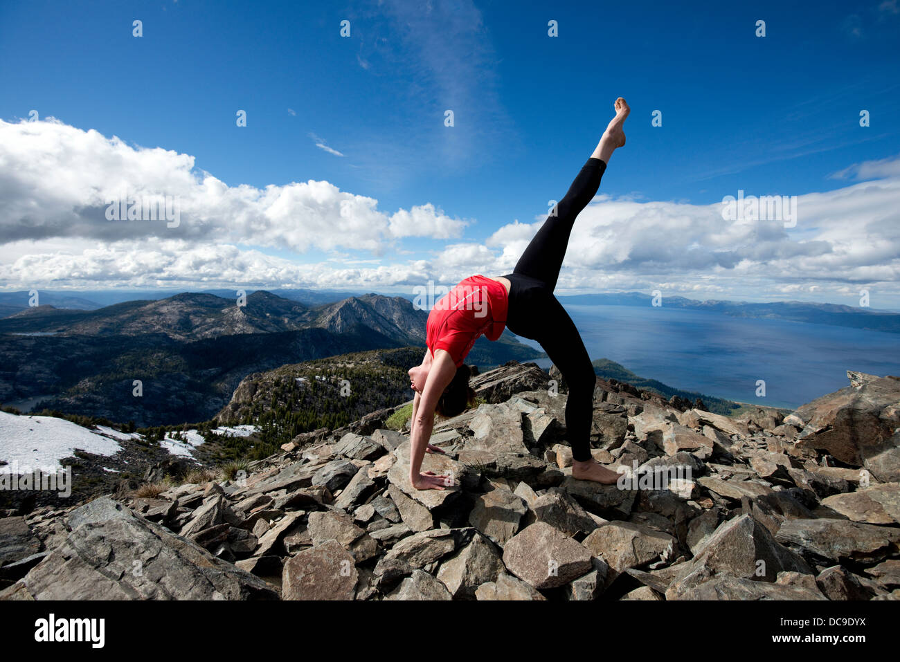 Une femme effectue le yoga au sommet du mont Tallac surplombant le lac Tahoe sur une belle après-midi près de South Lake Tahoe, CA. Banque D'Images