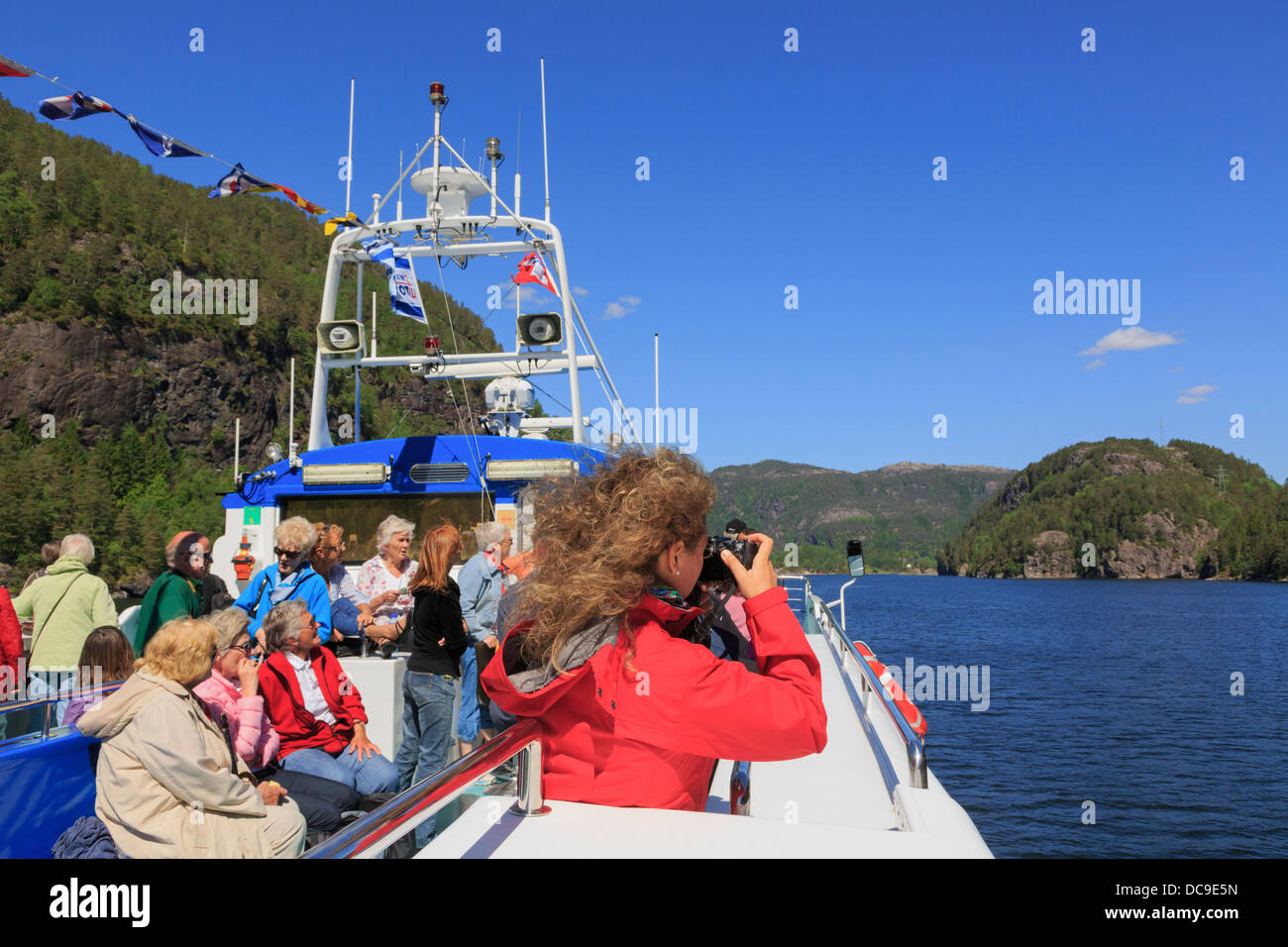 Femme de prendre une photo sur un bateau de croisière touristique les touristes le long du fjord Osterfjorden de Bergen, Hordaland, Norvège, Scandinavie Banque D'Images