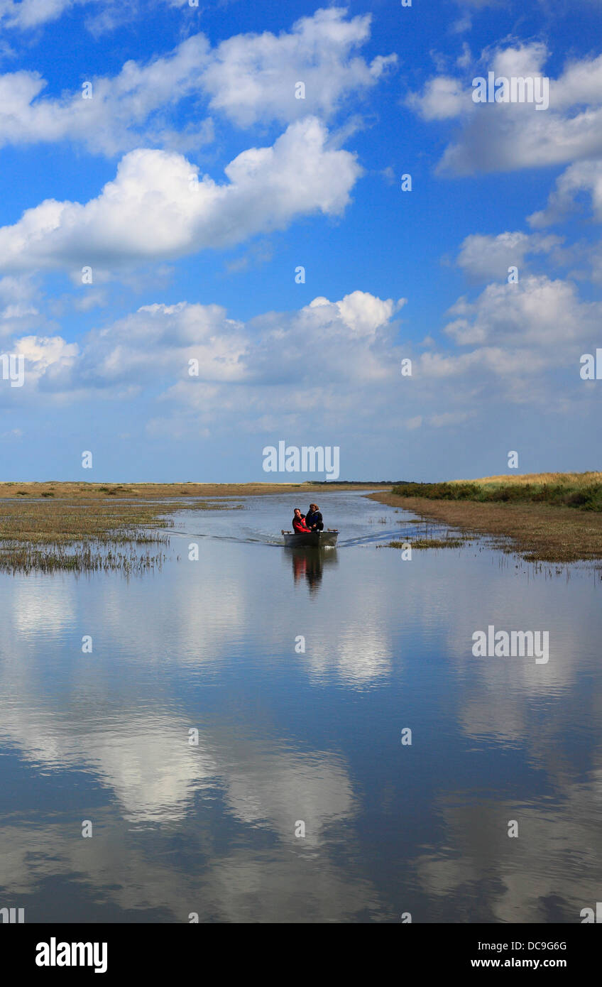 Père et fils à bord d'un ruisseau inondés à marée haute sur la côte nord du comté de Norfolk. Banque D'Images