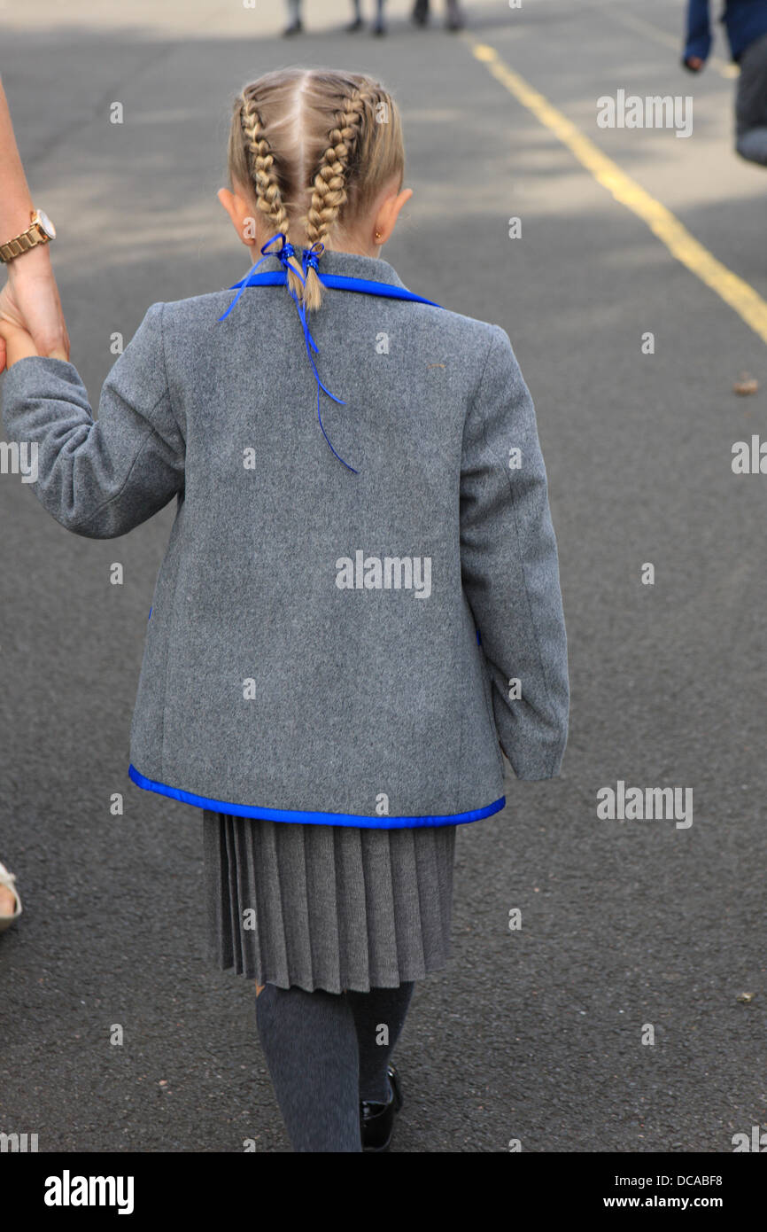 East Renfrewshire, en Écosse, au Royaume-Uni. 14 août 2013. Jeune fille de 4 ans dans sa nouvelle école tenue uniforme sur la main de sa mère alors qu'elle prend ses premiers pas dans la cour de l'école pour le premier jour de l'école primaire de East Renfrewshire Scotland comme les écoles écossaises retour après les vacances d'été. Credit : PictureScotland/Alamy Live News Banque D'Images