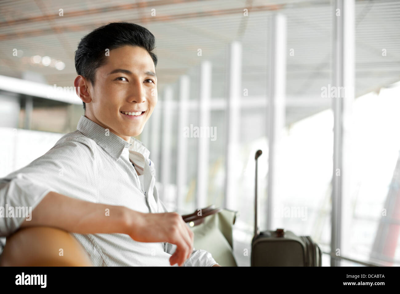 Jeune homme attendant in airport lounge Banque D'Images