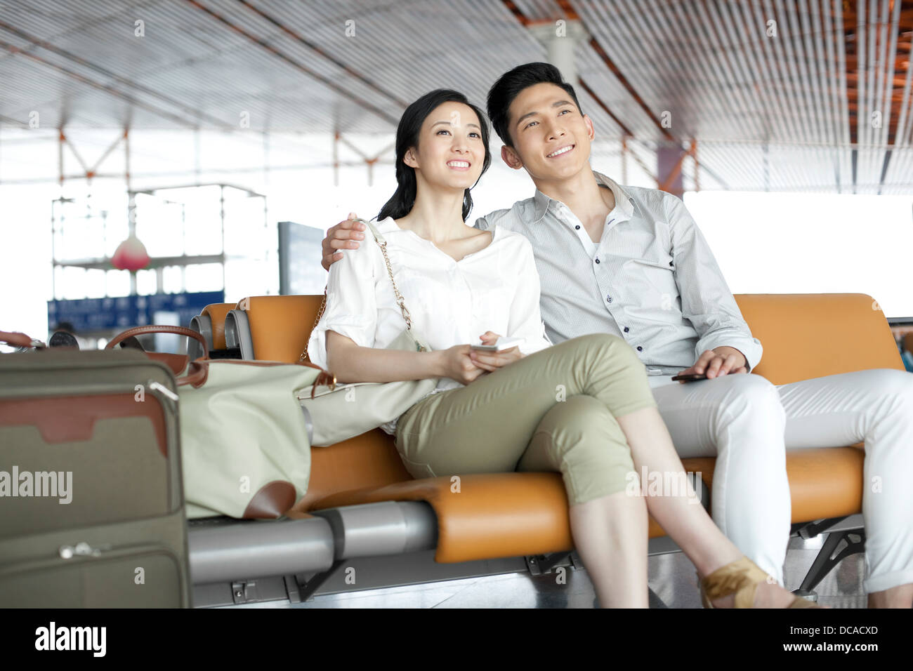 Jeune couple en attente in airport lounge Banque D'Images