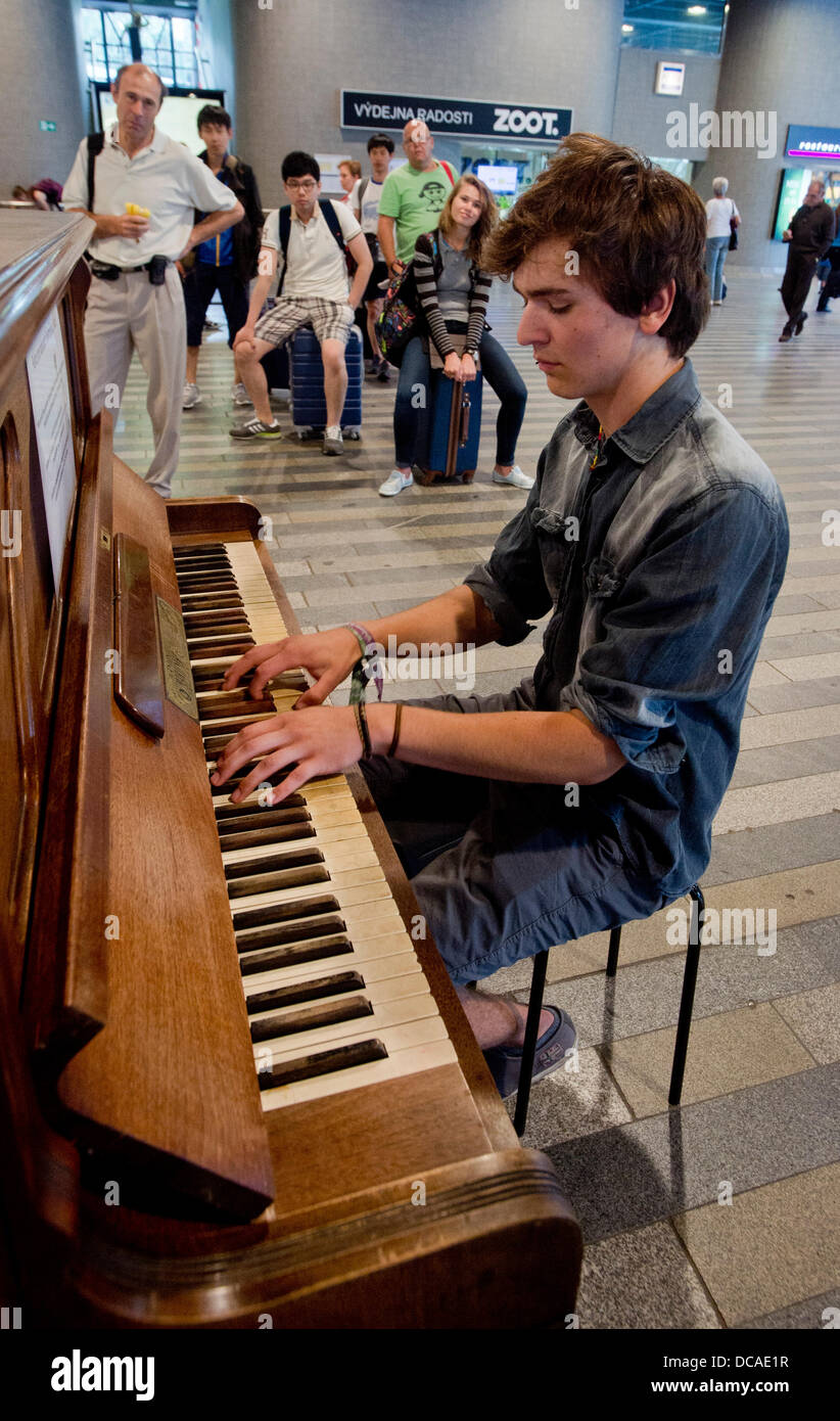 Prague, République tchèque. 13 août 2013. Des gens jouer du piano à l'accès  public de la gare principale de Prague, République tchèque en tant que  propriétaire de café Kobza Ondrej placé sur