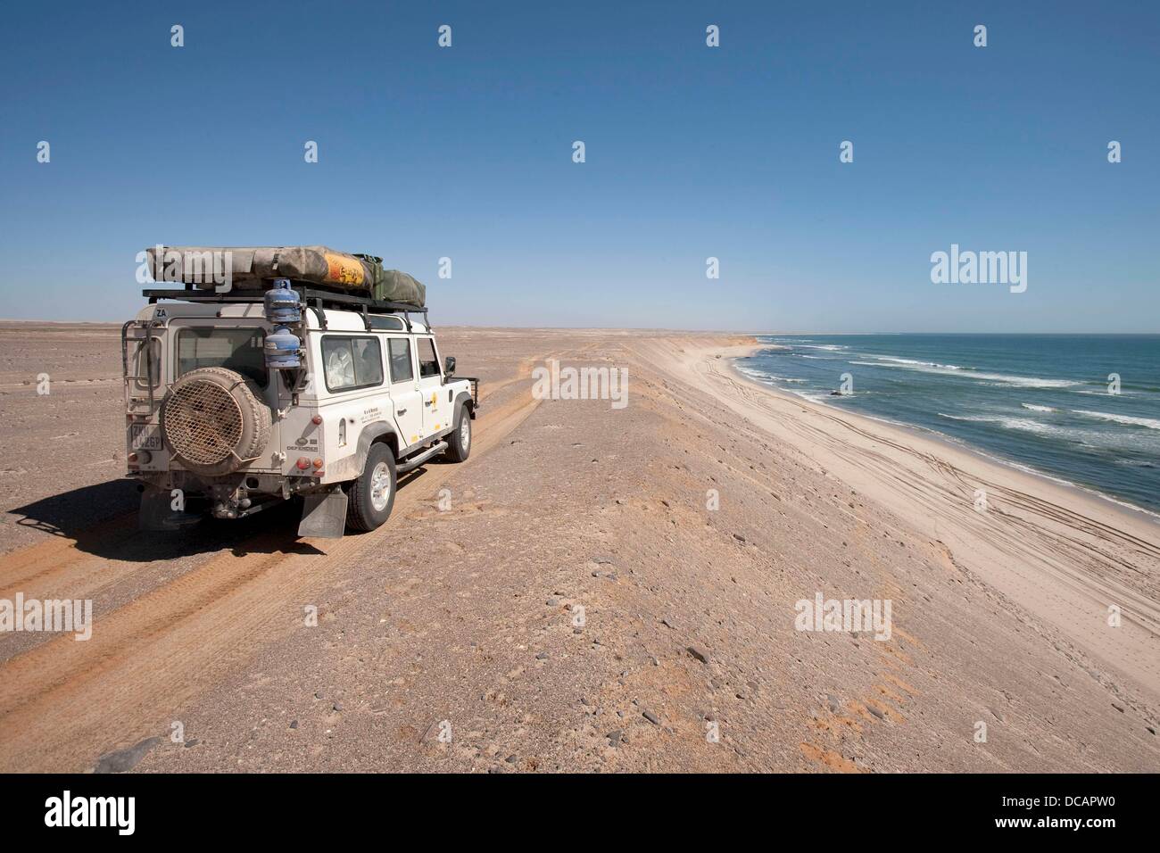 Un Land Rover Defender voyages sur la plage le long de la côte de l'océan Atlantique près de Torra Bay Resort sur la Côte des Squelettes de Skeleton Coast National Park, Namibie, le 15 décembre 2010. Photo : Tom Schulze Banque D'Images