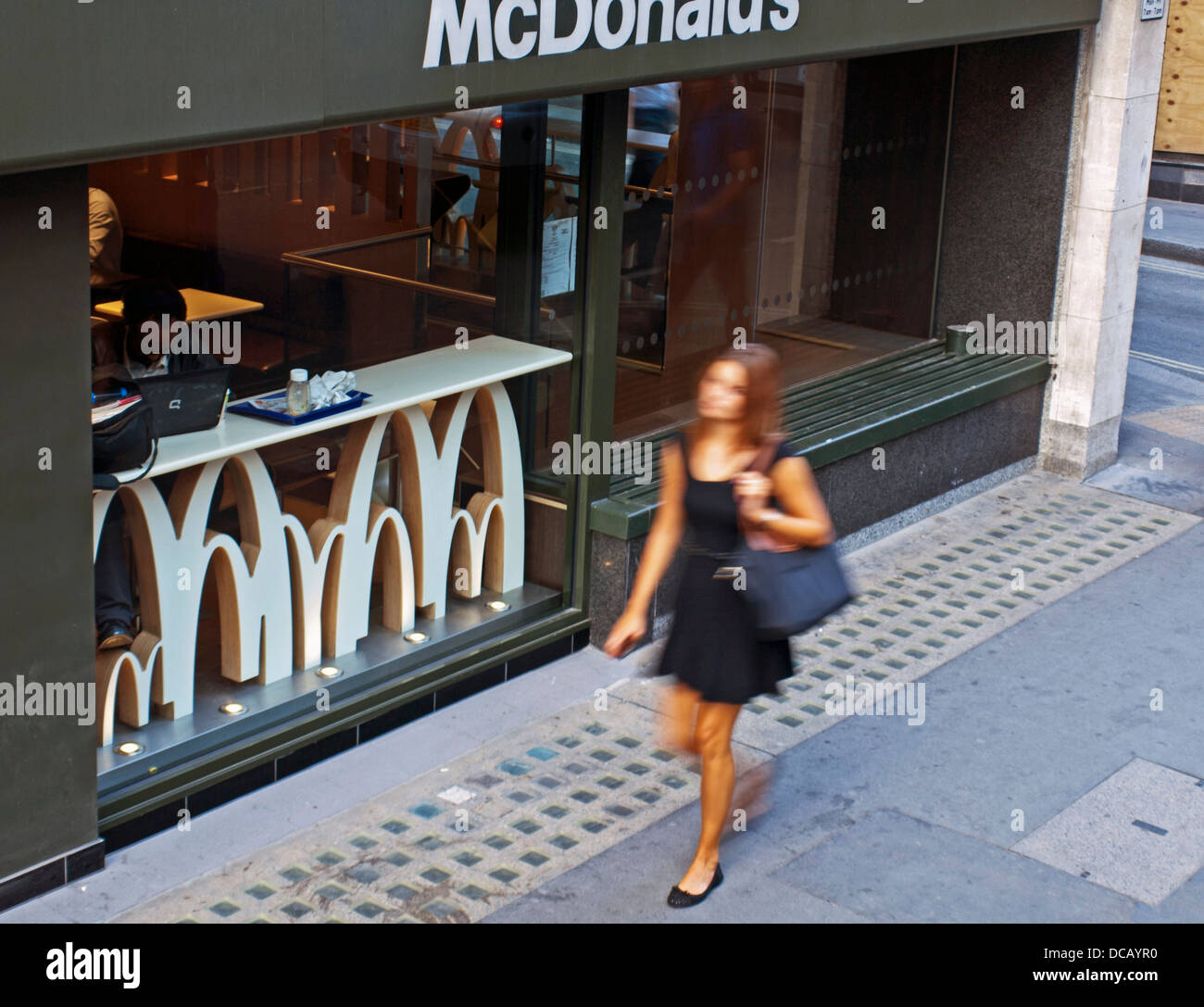 Jeune femme marchant devant Mcdonald's restaurant fast food, Strand Banque D'Images