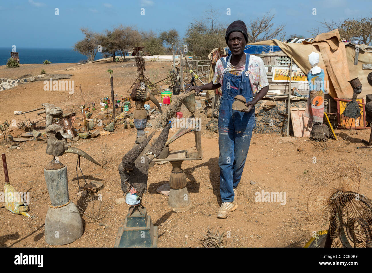 Artiste Amadou Dieng entouré par ses créations d'objets trouvés et récupérés. L'île de Gorée, au Sénégal. Banque D'Images