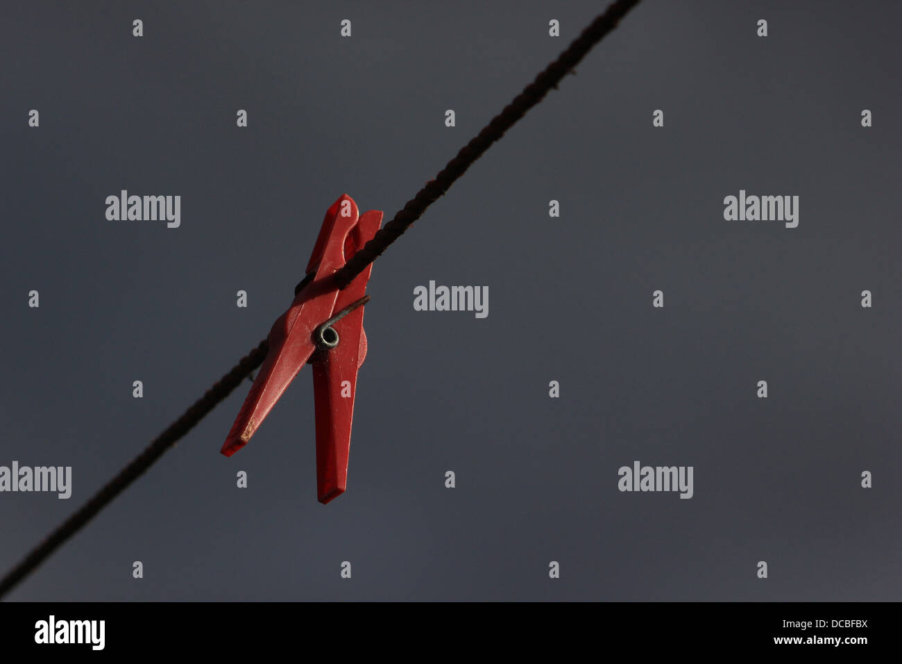 Vêtements rouge peg sur lave-ligne avec fond de ciel sombre Banque D'Images