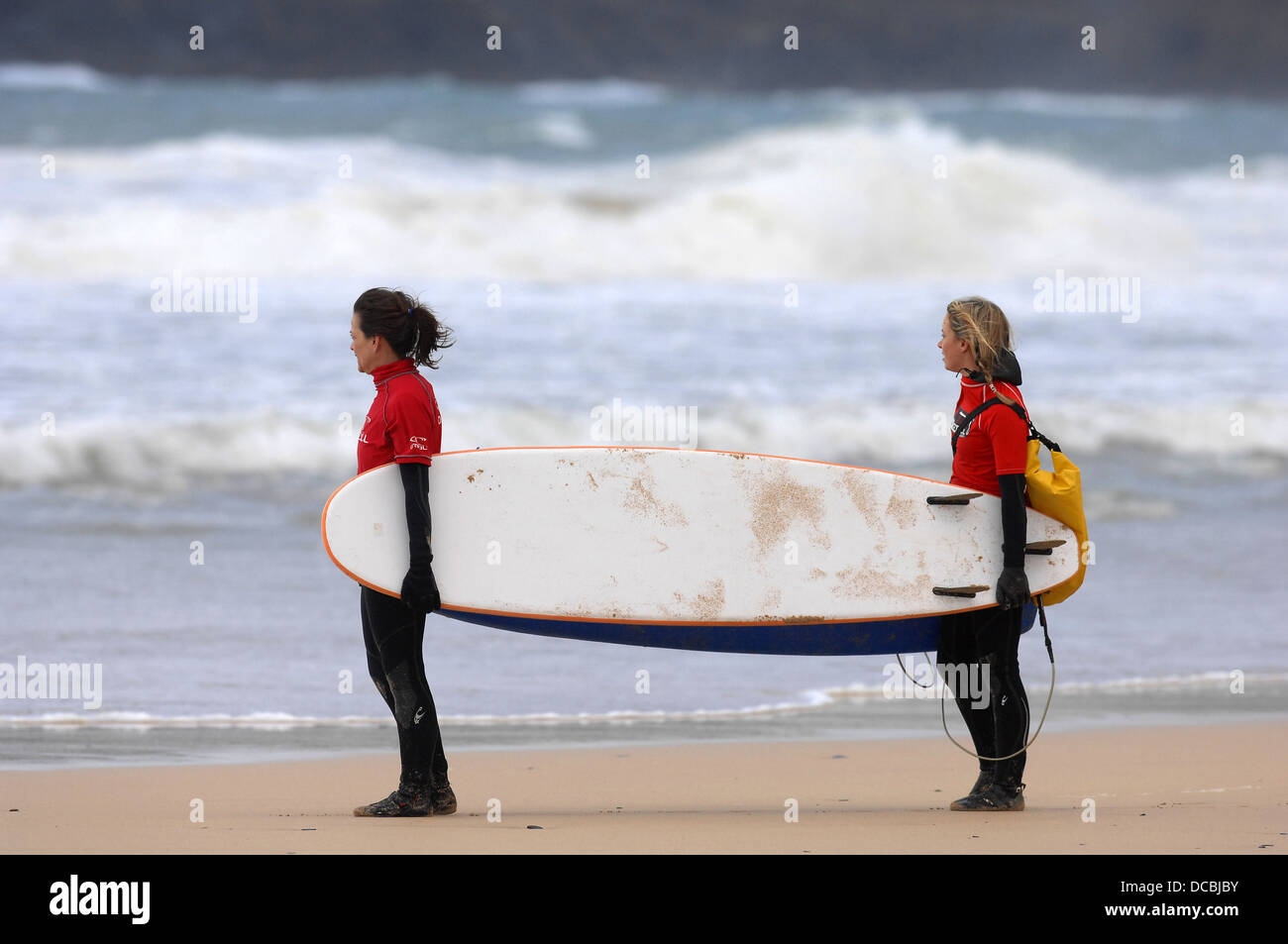 Deux jeunes femmes se préparent à aller faire du surf à Cornwall Banque D'Images