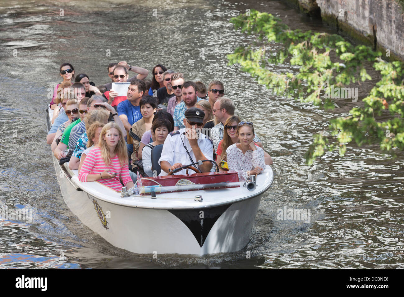 Bateau d'excursion avec les touristes sur un canal ou gracht à Bruges, Brugge, Flandre orientale, Belgique Banque D'Images