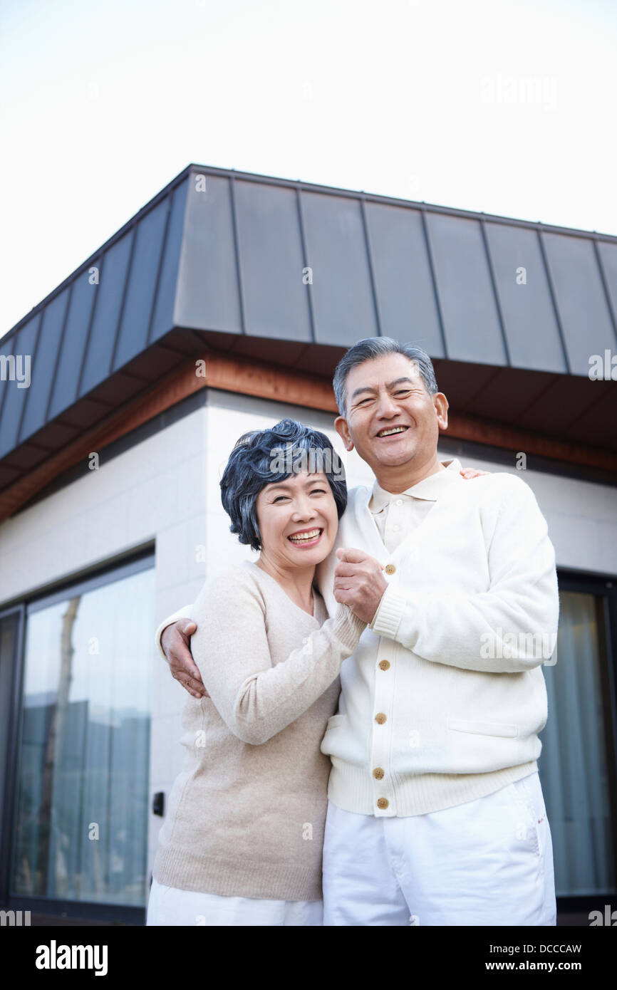 Couple hugging on a garden in front of house Banque D'Images