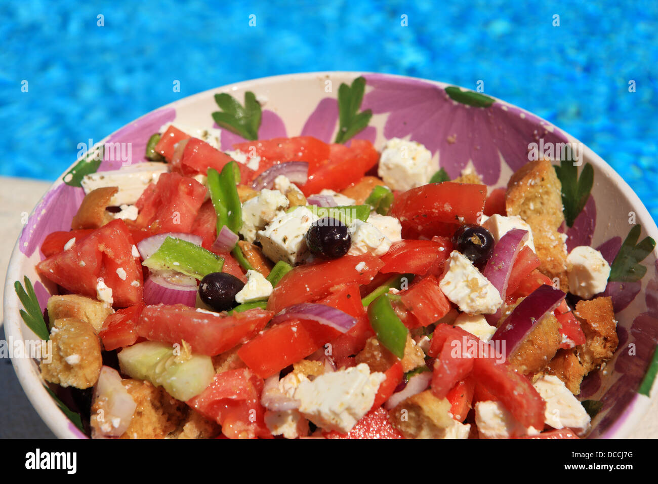 Salade grecque dans un bol fleuri par une piscine en Grèce Banque D'Images