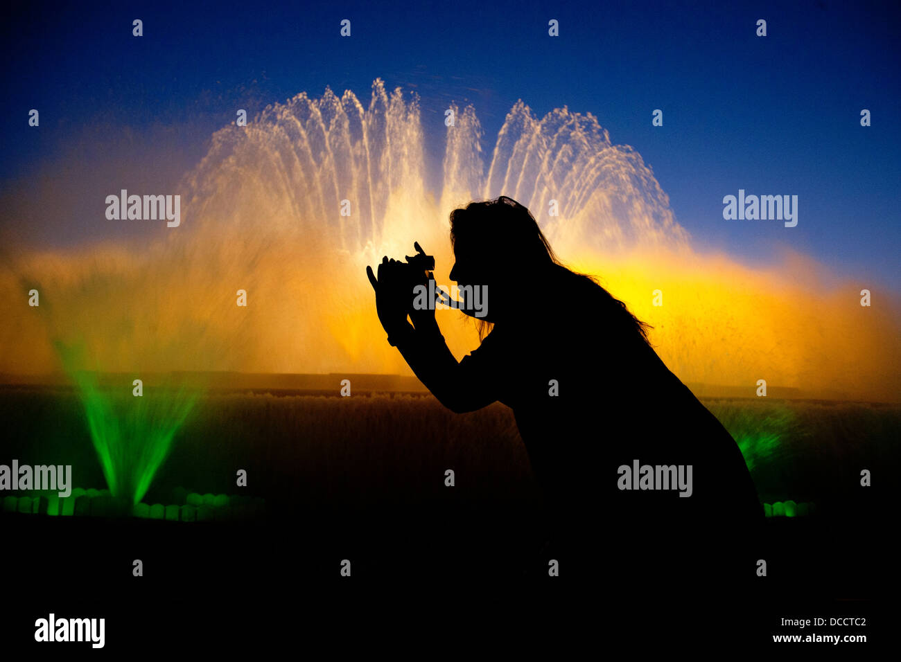 Silhouette femme de prendre des photos de la magie des fontaines de Montjuic, Barcelone, Espagne. Banque D'Images