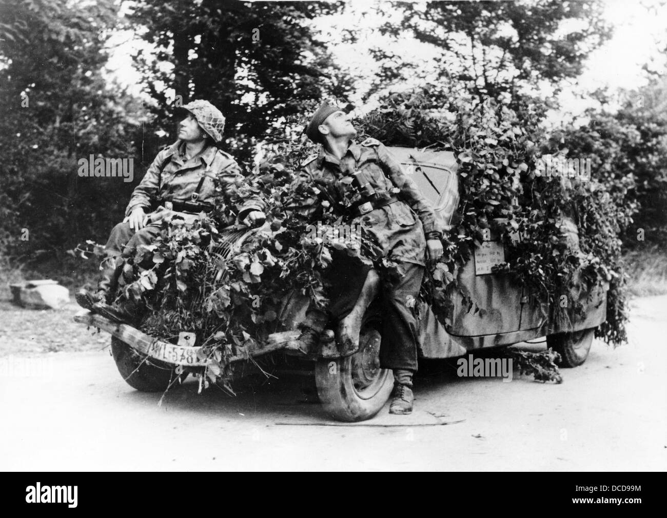 Des membres de la Wehrmacht allemande sont photographiés devant un véhicule camouflé en Normandie, en France, en juillet 1944. Fotoarchiv für Zeitgeschichte Banque D'Images