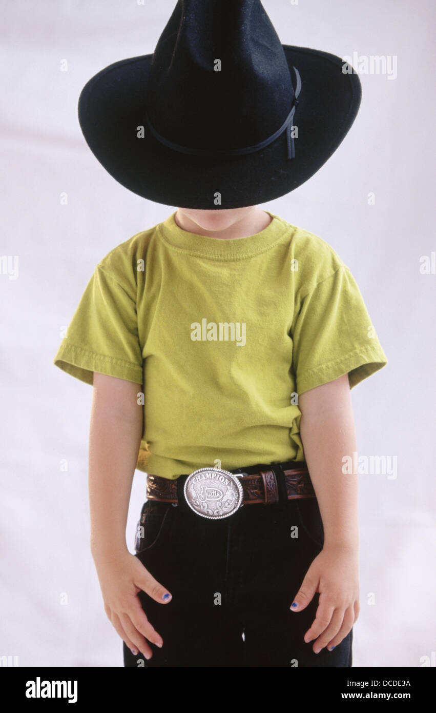 Garçon caché derrière un grand chapeau de cowboy noir et le port de ceinture  avec argent boucle Photo Stock - Alamy