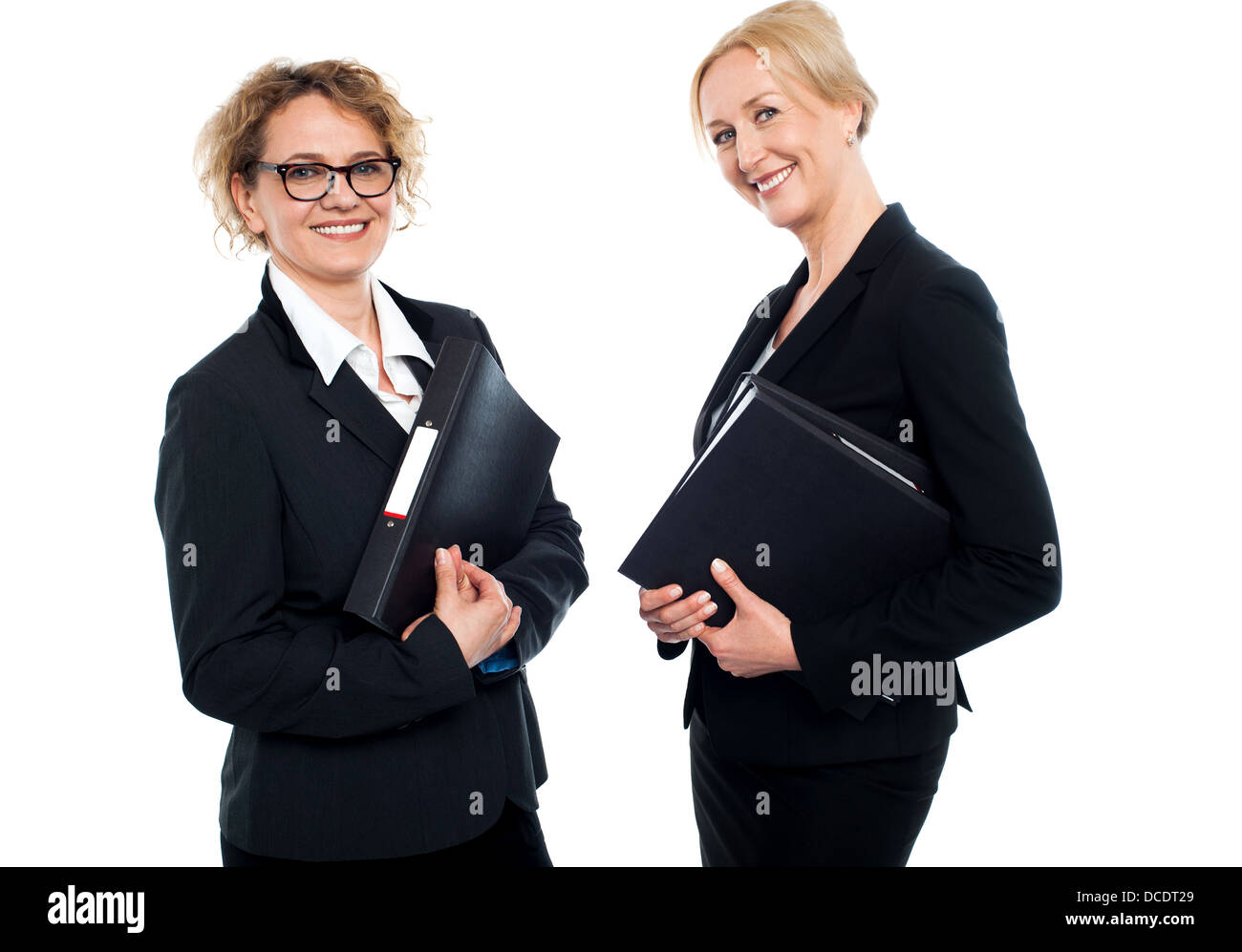 Les femmes d'affaires d'âge moyen heureux holding files and looking at camera Banque D'Images