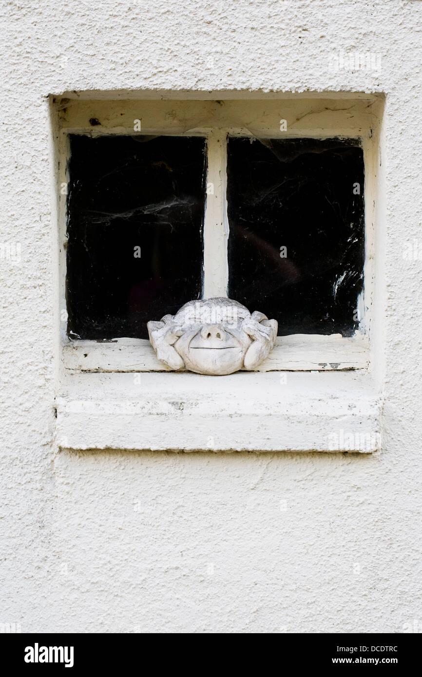 Visage de pierre sur un rebord de fenêtre. Banque D'Images