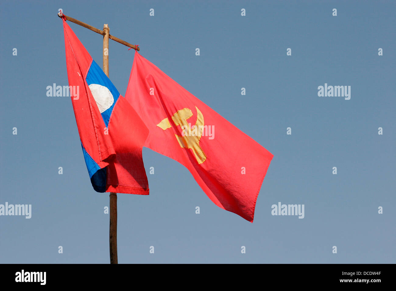 Drapeau national laotien et drapeau communiste avec un marteau et la faucille, Vientiane, Laos Banque D'Images