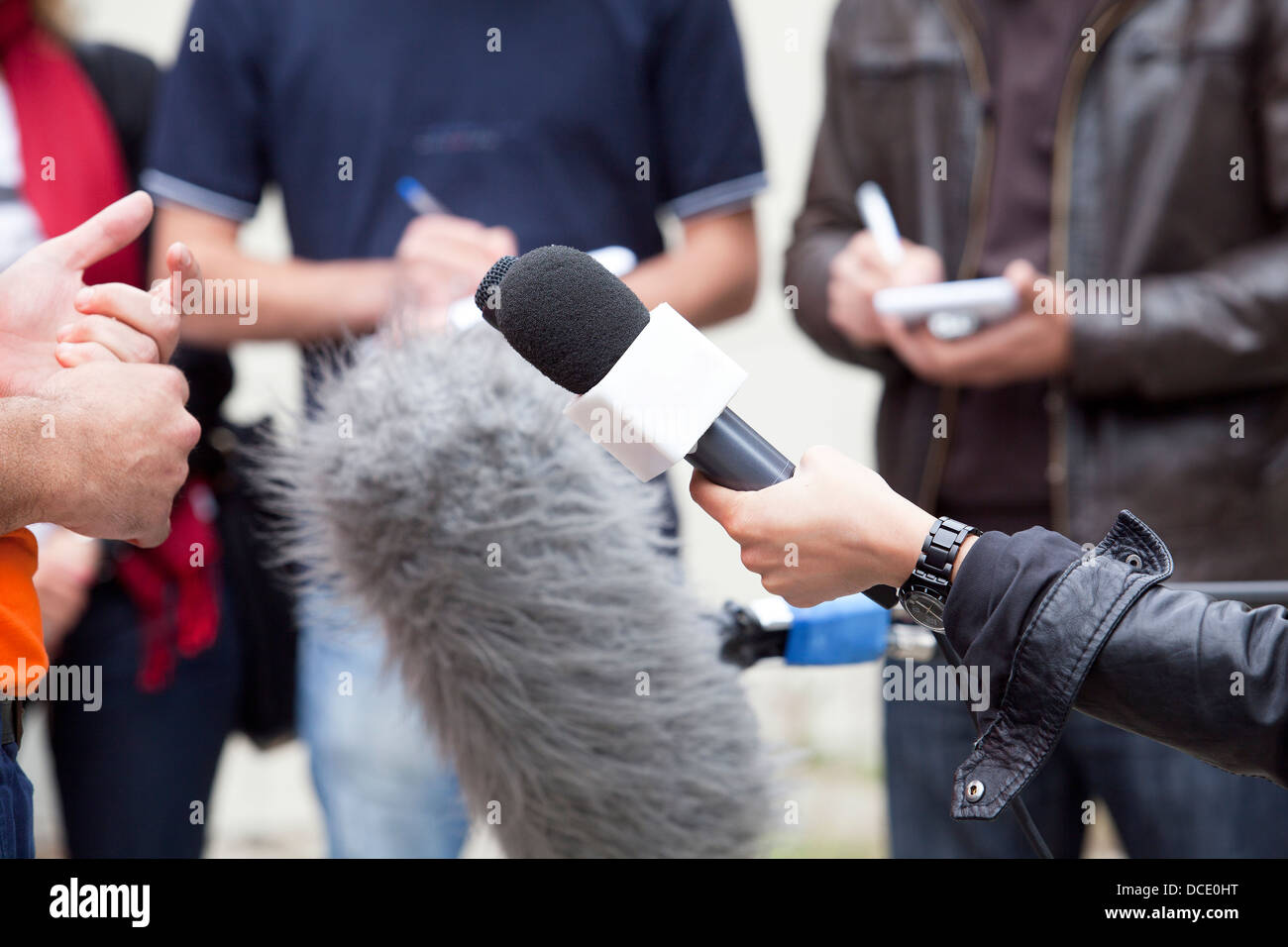 Un journaliste fait une interview avec un microphone Banque D'Images