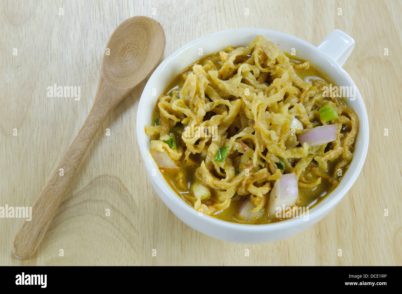 Dans un plat de nouilles au curry jaune bol blanc sur fond de bois Banque D'Images