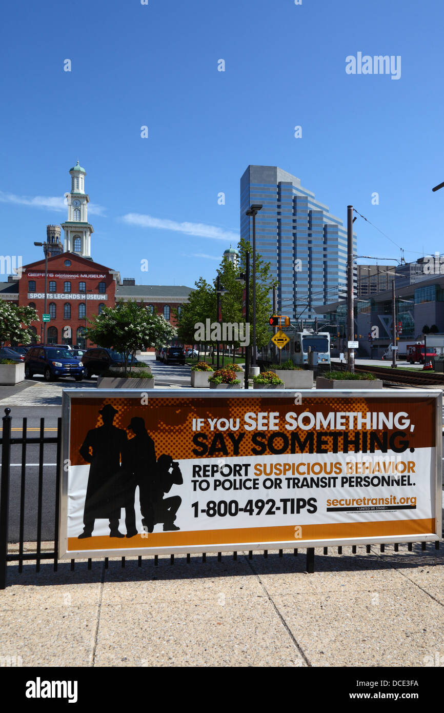 Signe encourageant les gens à signaler les comportements suspects, les Sports Legends Museum à gauche, en arrière-plan, Baltimore, Maryland, USA Banque D'Images
