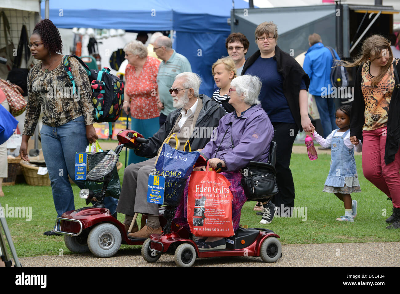 Couple de personnes âgées sur la mobilité des scooters à Shrewsbury Flower Show 2013 Banque D'Images