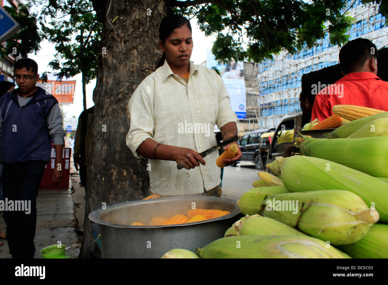 Femme indienne à un maïs torréfaction boutique routière à Bangalore Banque D'Images