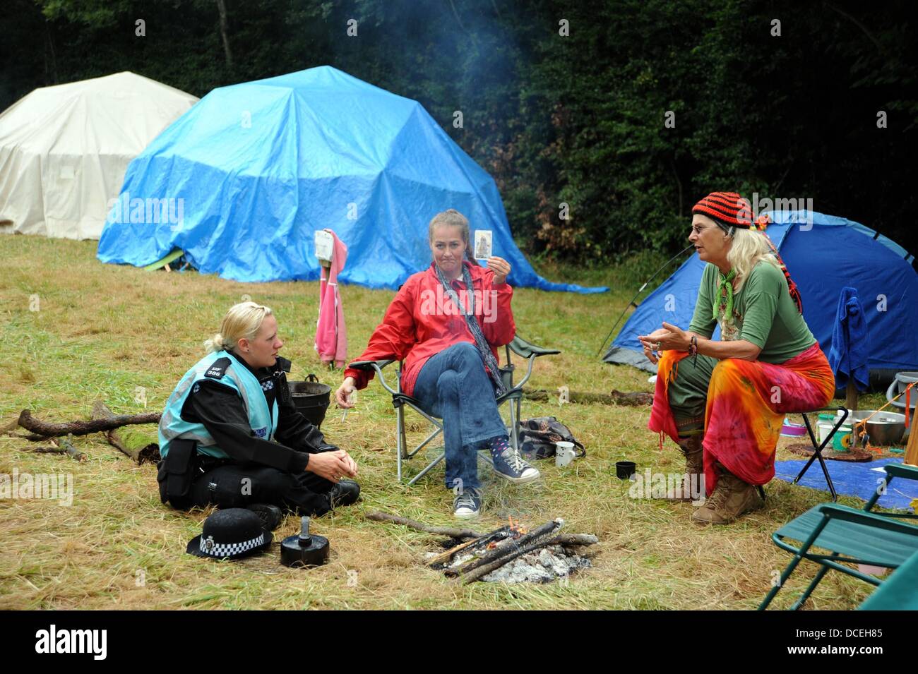 Balcombe Sussex UK 16 Août 2013 - Un officier de liaison de la police s'entretient avec des manifestants à côté d'un feu comme les militants anti Fracturation hydraulique se rassembler dans la Cuadrilla site dans le West Sussex village de Balcombe où l'entreprise sont l'exécution de forages d'exploration . Des milliers de manifestants devraient rejoindre la protestation sur le prochain week-end. Banque D'Images