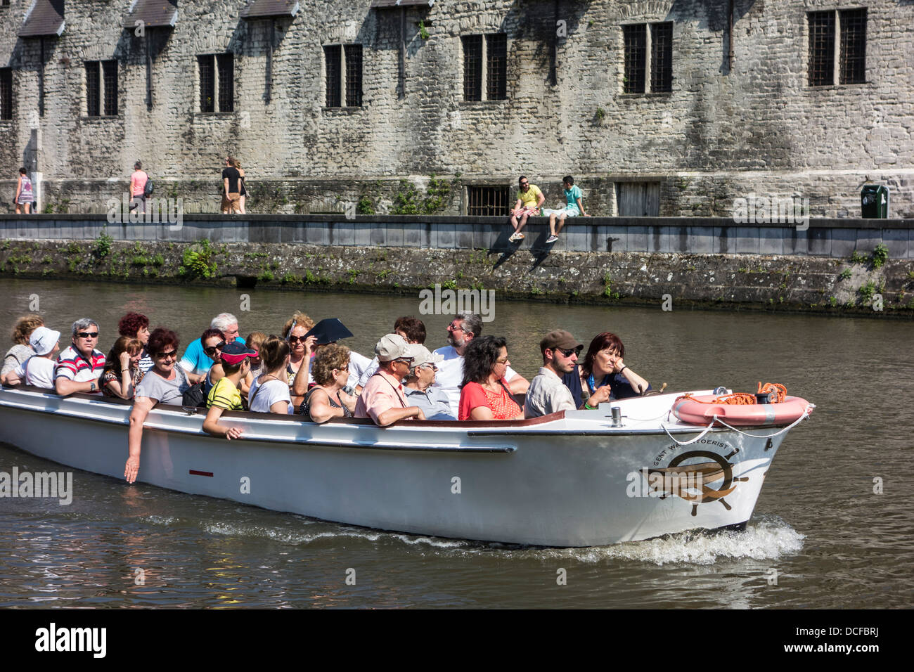 Les touristes en bateau sur la rivière Lys / Lys au cours de voyage touristique à la recherche à la Groot Vleeshuis / grande boucherie à Gand, Belgique Banque D'Images