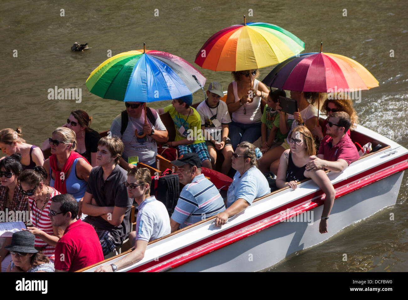 Les touristes avec des parasols en bateau sur la rivière Lys Lys / excursion touristique guidé au cours de l'été à Gand, Flandre orientale, Belgique Banque D'Images