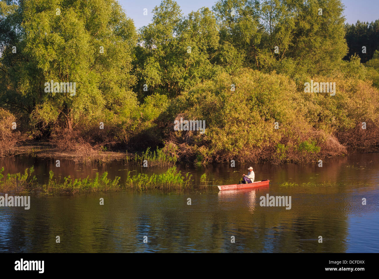 Vieil Homme Pêche hors d'un bateau à rames Banque D'Images