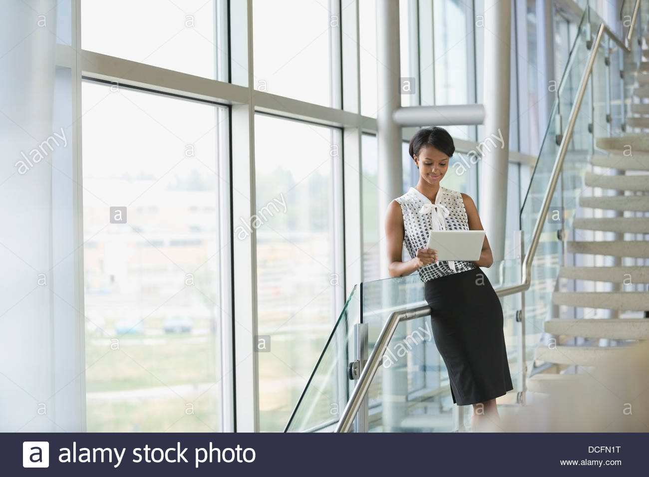 Businesswoman using digital tablet on staircase Banque D'Images