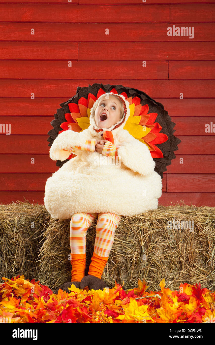 Une jeune fille dans un costume de la Turquie assis sur une balle de foin et le chant ; Three Hills, Alberta, Canada Banque D'Images