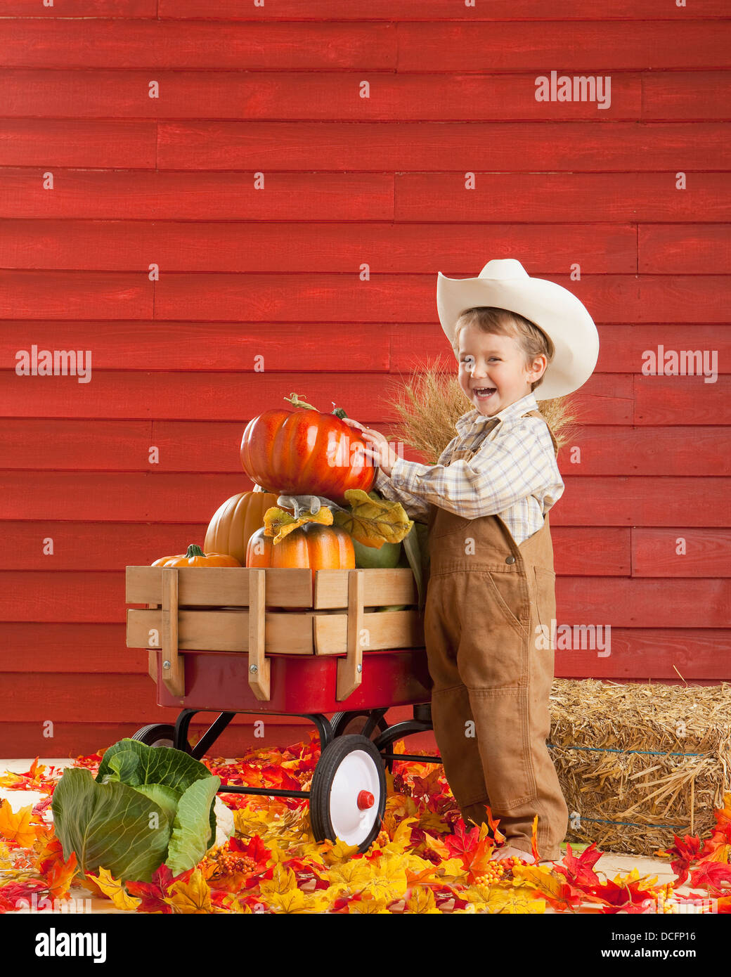 Un garçon vêtu comme un agriculteur avec un chariot plein de produire ; Three Hills, Alberta, Canada Banque D'Images