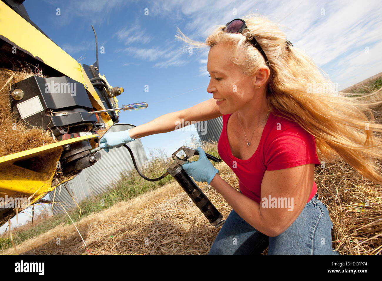 Une femme travaille avec l'équipement pour la récolte du blé ; Three Hills, Alberta, Canada Banque D'Images