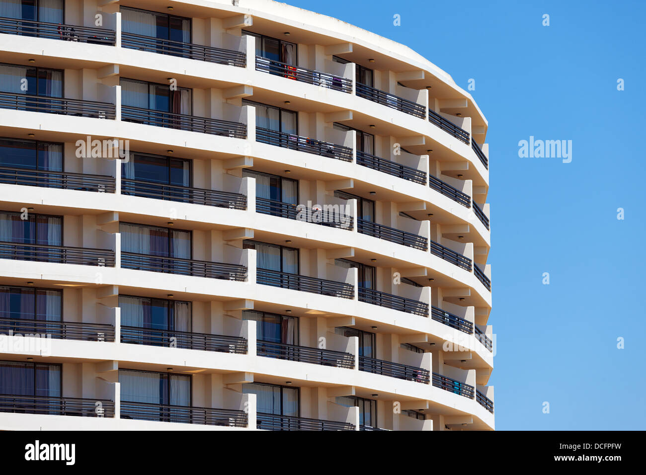 Extérieur d'une résidence moderne ou à l'hôtel avec un design arrondi incurvé contre un ciel bleu Banque D'Images