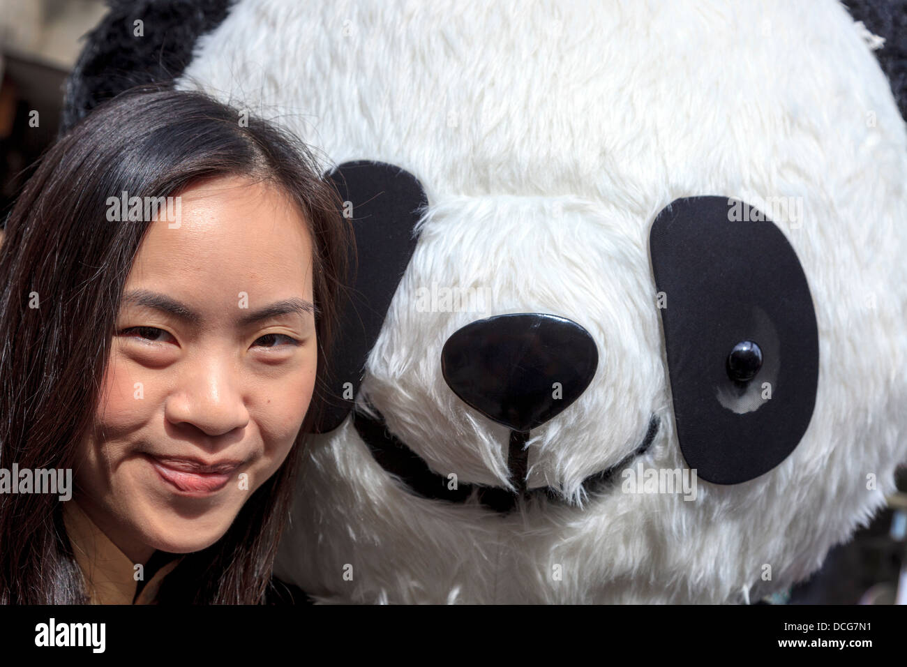 Julie Chewng-Inhin, effectuant à l'Edinburgh Fringe Festival avec un grand panda jouet, High Street, Edinburgh, Ecosse, Royaume-Uni Banque D'Images