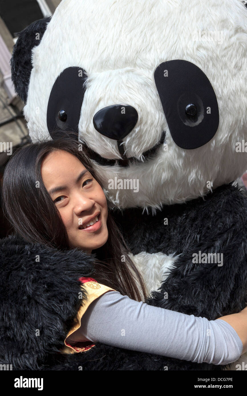 Julie Chewng-Inhin, effectuant à l'Edinburgh Fringe Festival avec un grand panda jouet, High Street, Edinburgh, Ecosse, Royaume-Uni Banque D'Images