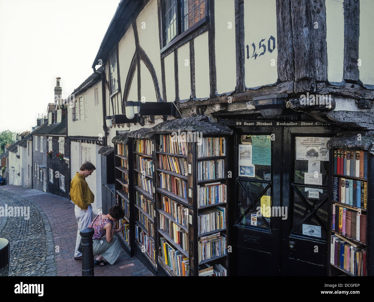 Un couple parcourt le xve siècle librairie, 99-100 High Street, Lewes, East Sussex Banque D'Images