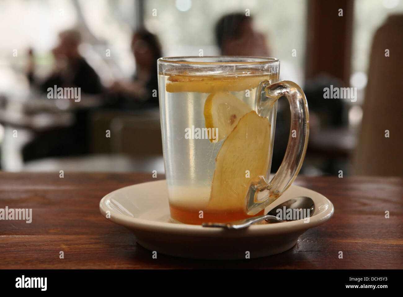 Un verre d'eau chaude avec du citron et du miel n'est pas mise au point les gens à l'arrière-plan Banque D'Images