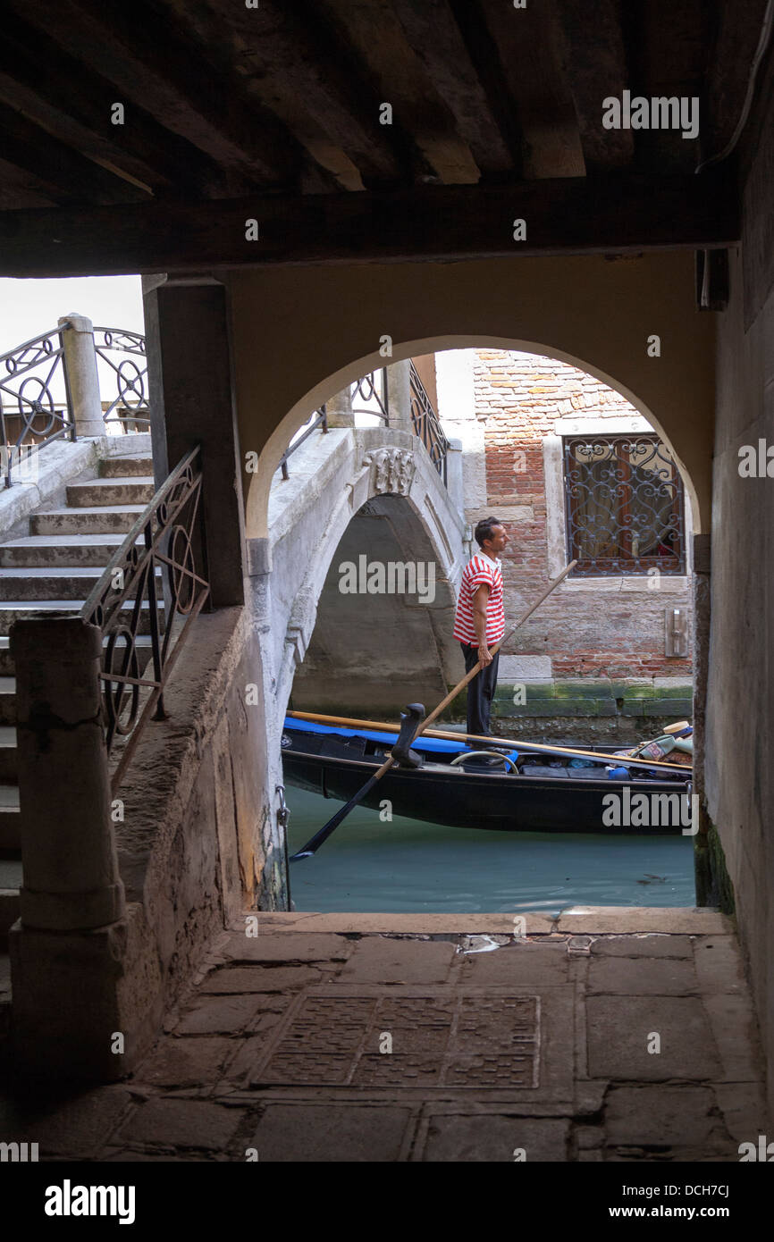 Un rameur d'aviron vénitien debout sa gondole après esquiver une surbased  bridge (Venise - Italie Photo Stock - Alamy