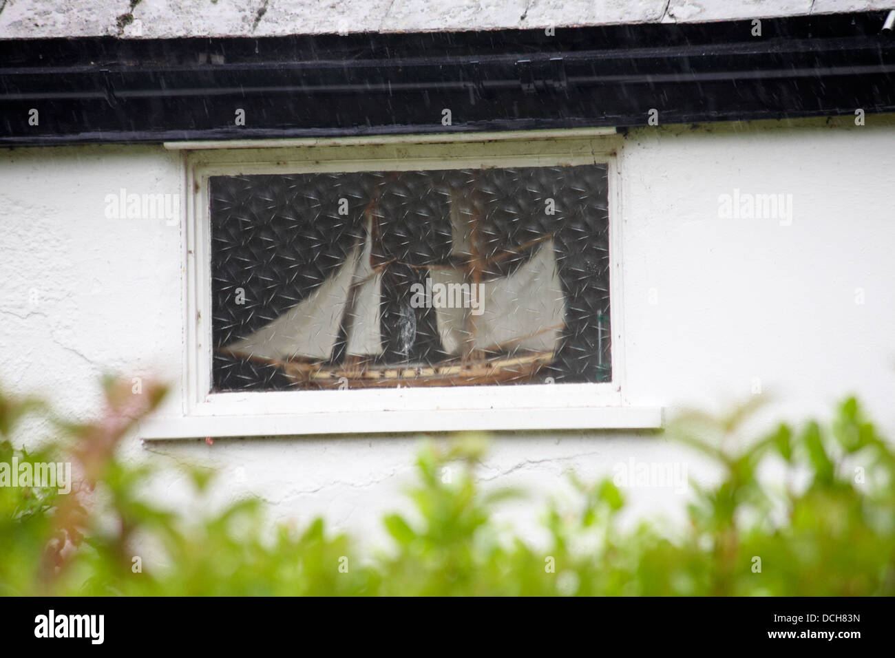 Bateau modèle dans la fenêtre de la maison à Lyme Regis, Dorset UK en août Banque D'Images