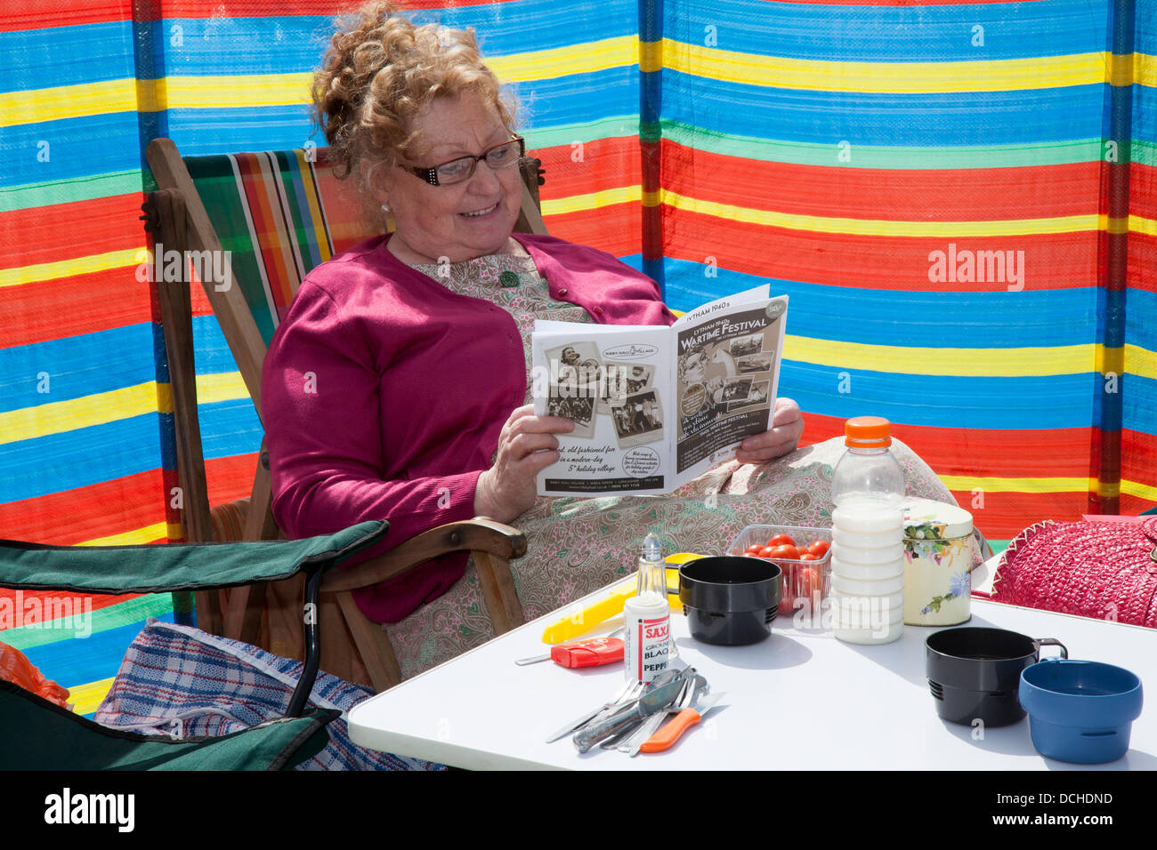 Table de pique-nique à Lytham, Blackpool. 18 août 2013. Hilary Wilkinson de Leigh, lisant le programme des événements du Lytham 1940's Wartime Festival qui s'est tenu à Lytham Green, Lancashire, Royaume-Uni. Banque D'Images