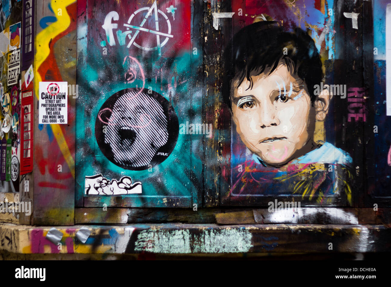 Graffitis colorés dans la rue adjacente au Columbia Road. Référence ironique aux photographes de rue Banque D'Images
