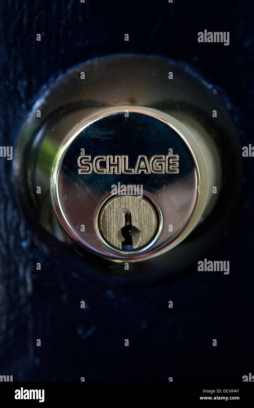 Vue détaillée d'une serrure à pêne dormant Schlage laiton sur une porte noire Banque D'Images