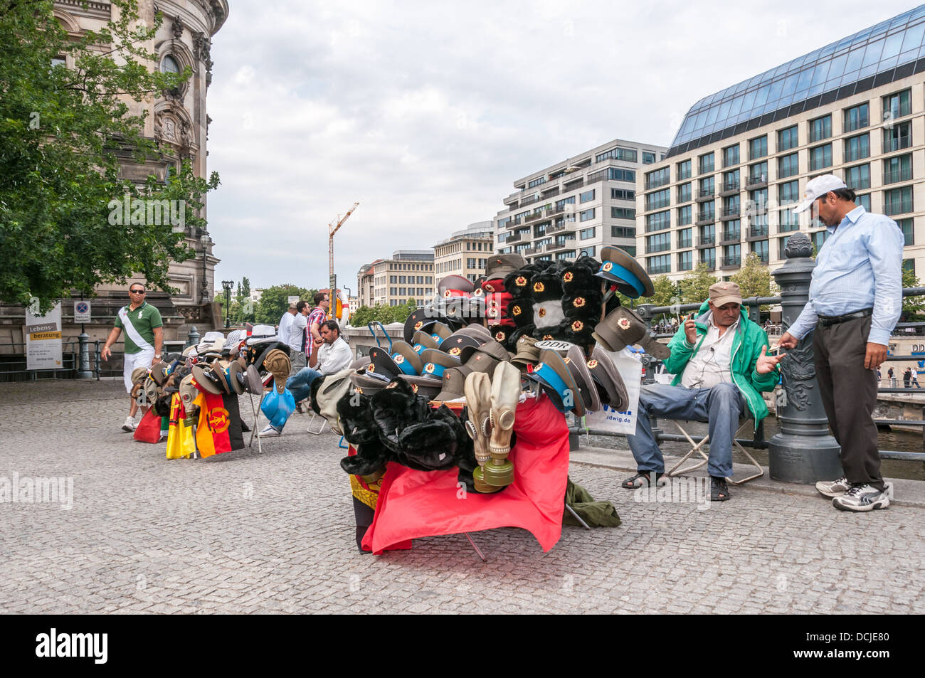 Les hommes du Moyen-Orient, les vendeurs de rue, la vente de souvenirs militaires, visored caps, drapeaux, à la Cathédrale de Berlin - Berlin Allemagne Banque D'Images